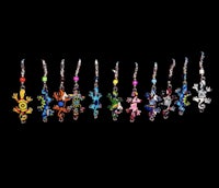 a row of colorful frog earrings on a black background